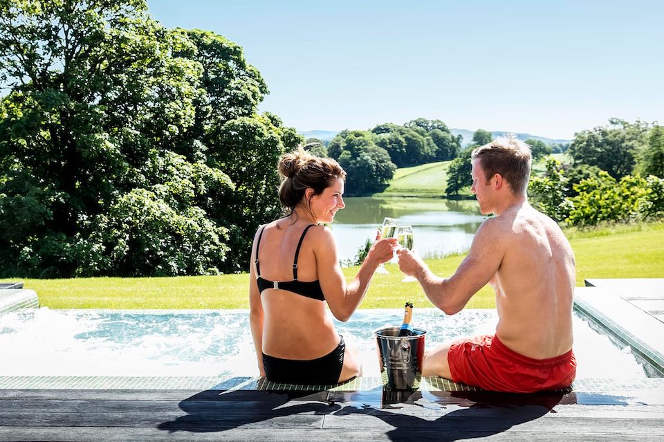 Coniston Spa Offer - couple cheers by the pool